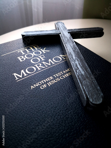 Wood cross and Holy Bible on the table photo