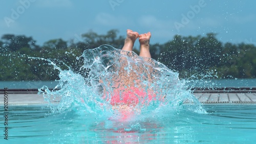CLOSE UP: Carefree female traveler jumps into cool beachfront pool in Vanuatu.