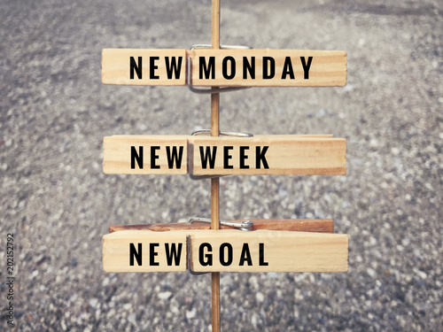 Motivational and inspirational quote. Words ‘New Monday, new week, new goal’ on wooden cloth clips.  photo