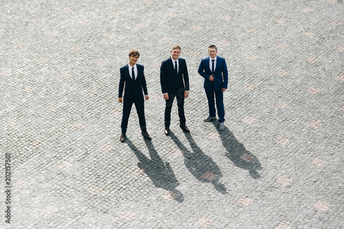 Look from above at groomsmen and groom waiting on the backyard for a bride