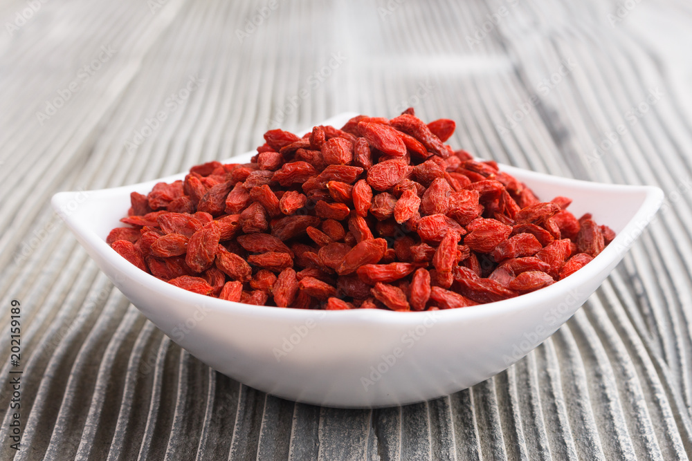 dried goji berries on a wooden rustic background dried goji berries on a wooden rustic background