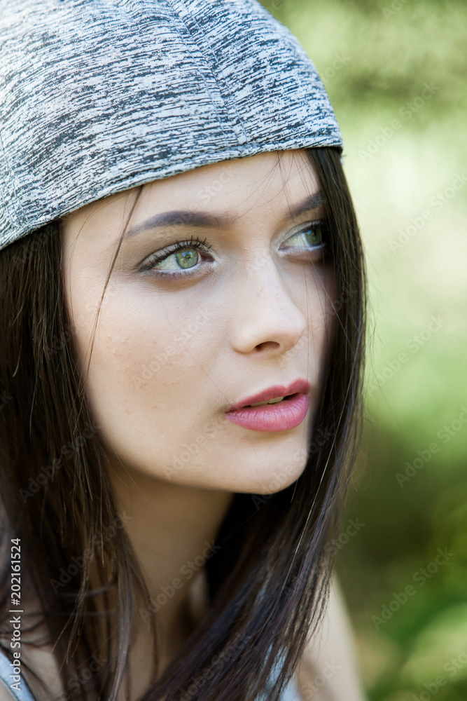 Beautiful girl with green eyes in city park. Woman beauty face portrait. Beautiful girl with green eyes in city park. Woman beauty face portrait.