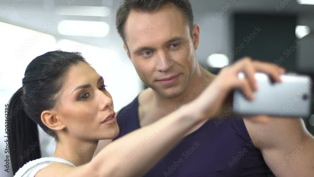 Sport couple taking selfie in gym, posting fitness routine in social network Sport couple taking selfie in gym, posting fitness routine in social network