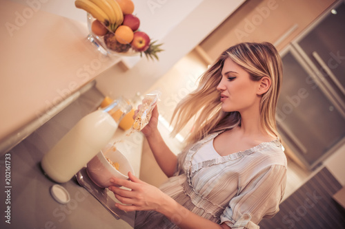 Smiling healthy woman eating cornflakes