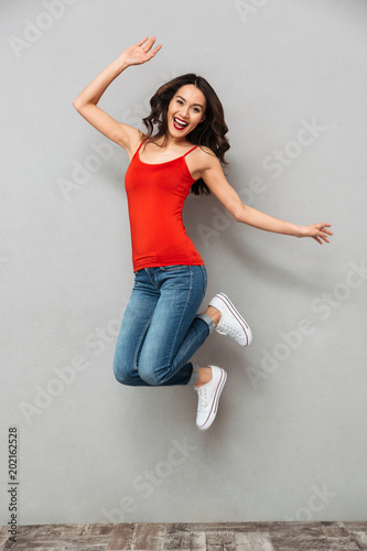 Full length image of Joyful brunette woman in casual clothes