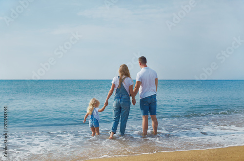 Fsmily with small kid and pregnant mom having vacation at warm sea beach or ocean