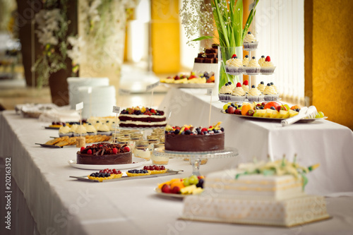 Many various cakes and desserts in candy bar at venue wedding celebration reception
