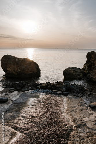 Seascape with rocks on beach during sunrise © Georgy