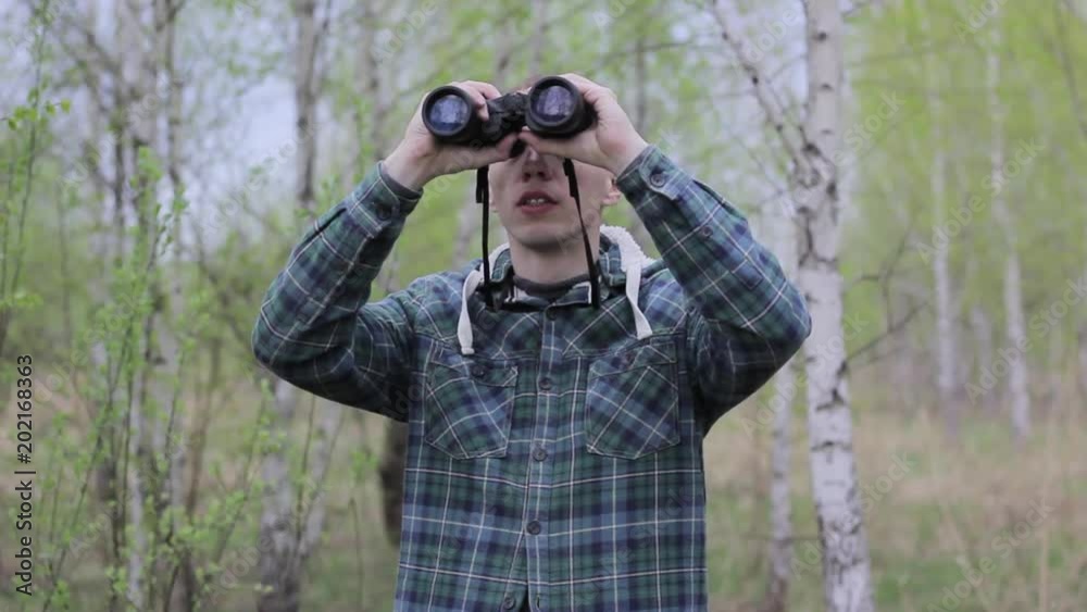 Tourist man looking through binoculars Tourist man looking through binoculars