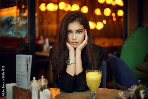 Young female brunette model in cafe