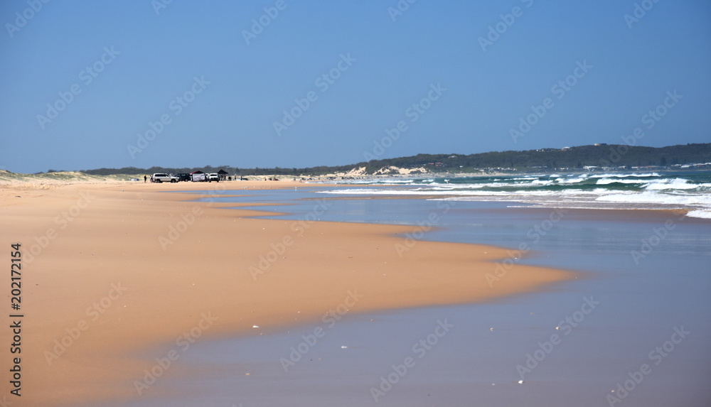 Horizontal landscape of the beach with cars. 4wd cars at Stockton beach (Anna bay, NSW, Australia).