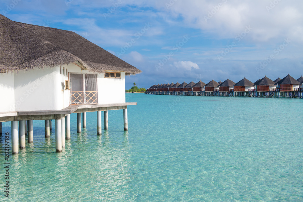 Beautiful tropical landscape with wooden villas over water of the Indian Ocean, Maldives island