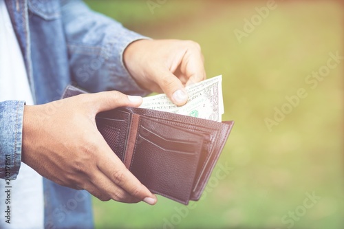 Businessman Person holding an wallet in the hands of an man take money out of pocket. photo