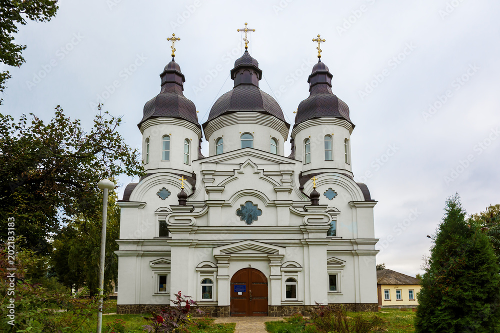 Temple of St. Peter Kalnyshevsky in Nedryhailiv, Sumska oblast, Ukraine. Beautiful white building with domes for religious purposes, Orthodox Church.
