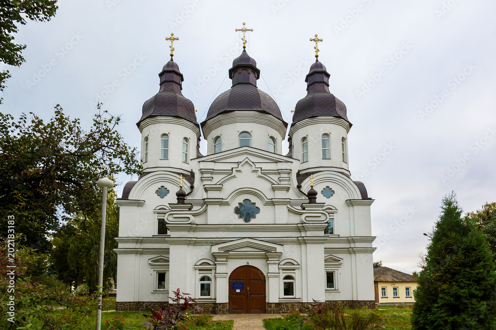 Temple of St. Peter Kalnyshevsky in Nedryhailiv, Sumska oblast, Ukraine. Beautiful white building with domes for religious purposes, Orthodox Church. Temple of St. Peter Kalnyshevsky in Nedryhailiv, Sumska oblast, Ukraine. Beautiful white building with domes for religious purposes, Orthodox Church.
