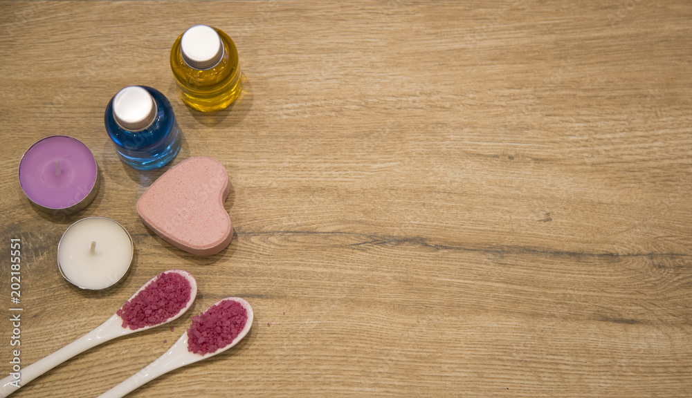 spa concept. pink bath salt , bath gel with candle on the wooden background spa concept. pink bath salt , bath gel with candle on the wooden background