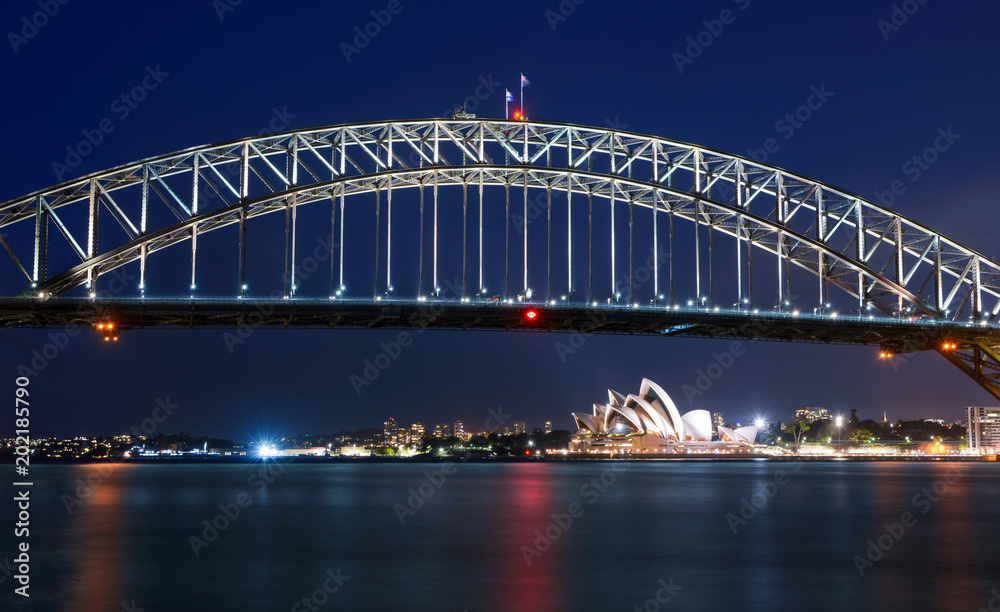Long exposure of Sydney Harbour Bridge at night against a deep blue sky