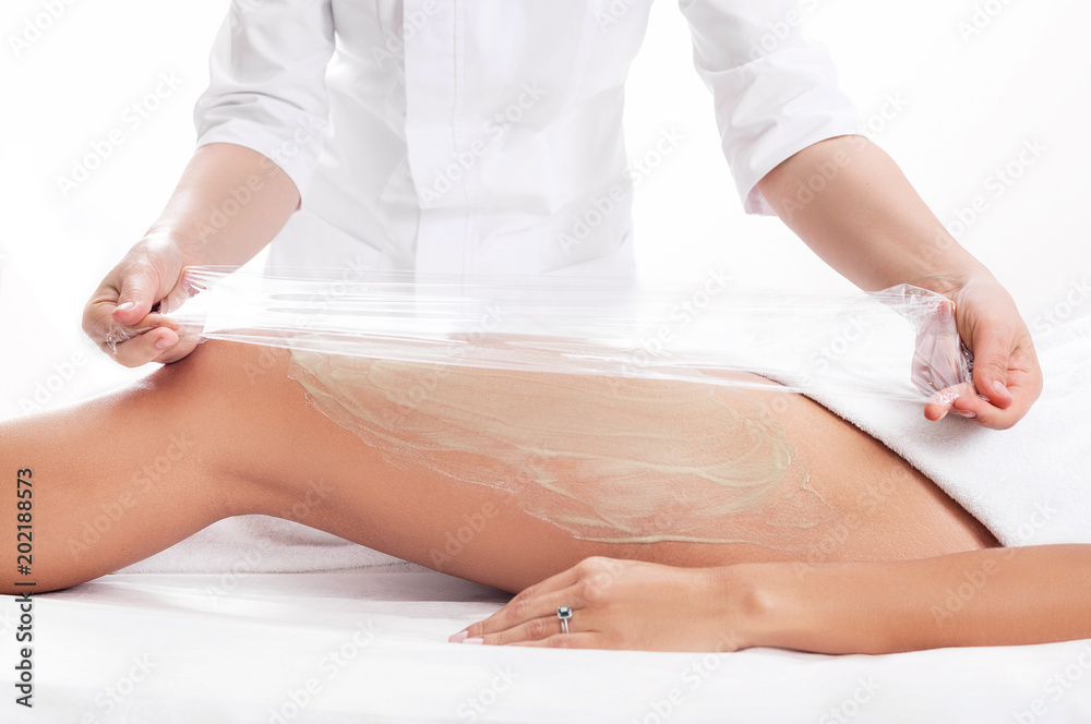 wrapping procedure by a cosmetologist - a cellulite mask Stock Photo |  Adobe Stock