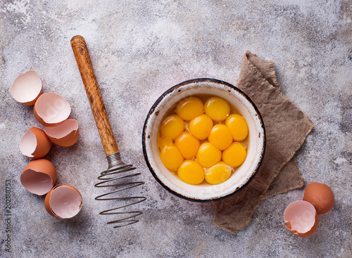 Bowl with eggs yolks and whisk photo