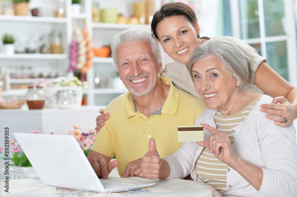 happy senior couple with adult daughter using laptop happy senior couple with adult daughter using laptop