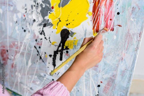 cropped image of female artist painting in workshop