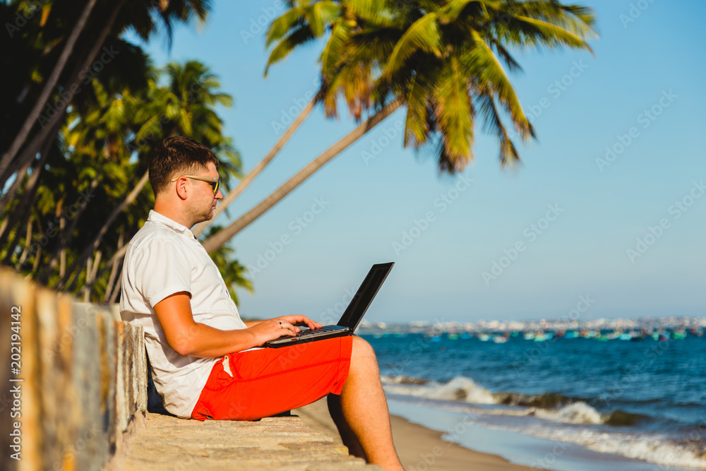 Business man on beach with laptop.