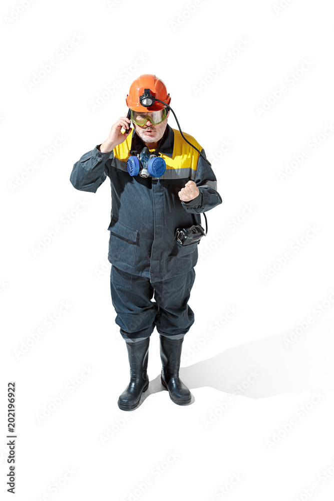 The studio shot of senior bearded male miner standing at the camera on a white background. The studio shot of senior bearded male miner standing at the camera on a white background.