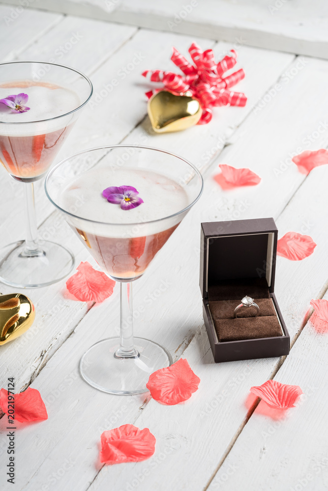 love, proposal, valentines day and holidays concept - close up of gift box with diamond engagement ring cocktails on white wood love, proposal, valentines day and holidays concept - close up of gift box with diamond engagement ring cocktails on white wood