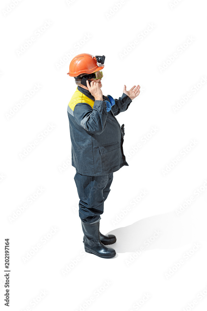 The studio shot of senior bearded male miner standing at the camera on a white background. The studio shot of senior bearded male miner standing at the camera on a white background.
