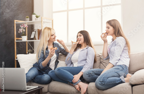 Happy women chatting and eating pizza at home
