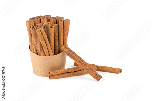 a lot of cinnamon sticks in a paper cup on a white background