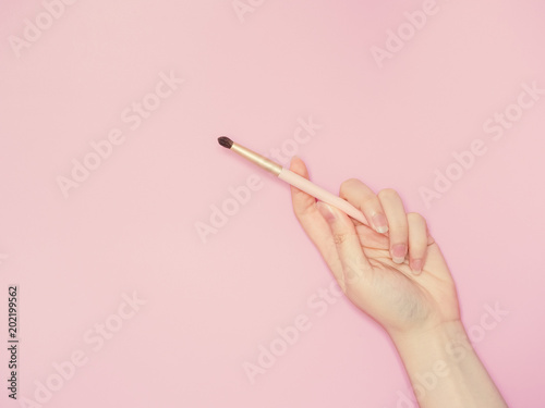 cosmetic and beauty concept from beauty asian hand hold and use cosmetic brush with isolated pink pastel background