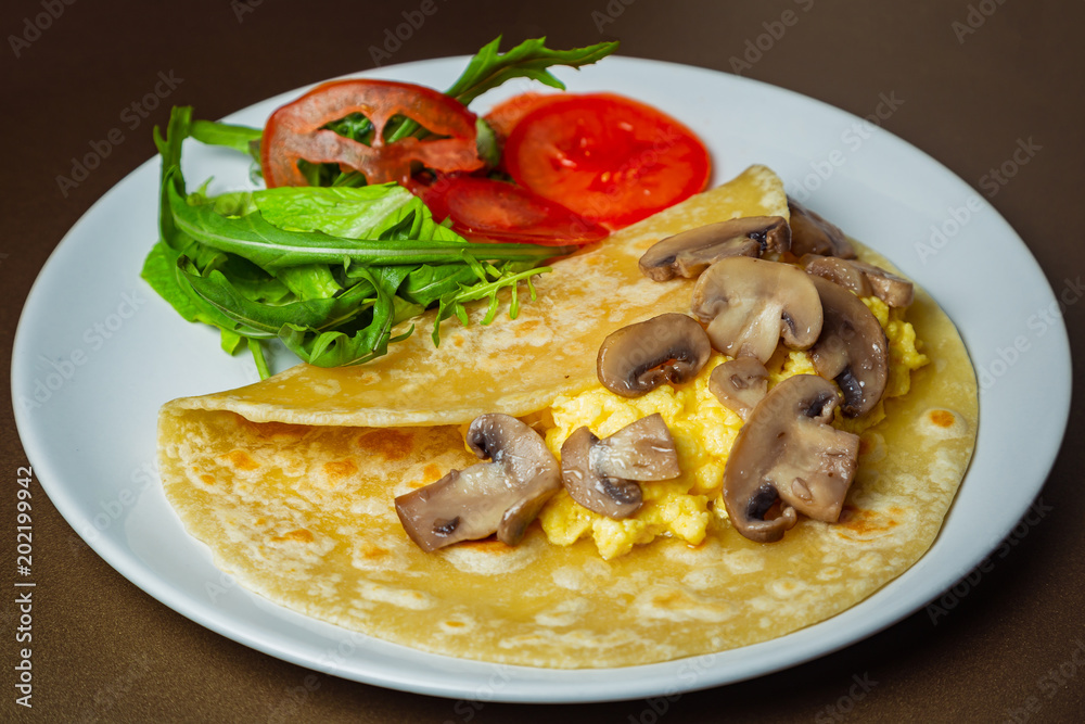 Scrambled eggs with mozzarella and champignon mushrooms on a white plate Scrambled eggs with mozzarella and champignon mushrooms on a white plate