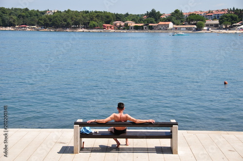 Raucher sitzt auf einer Bank am Meer