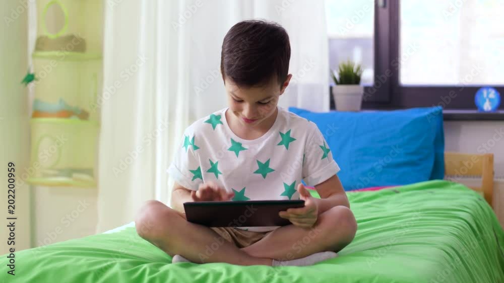 childhood, technology and people concept - smiling boy with tablet pc computer at home childhood, technology and people concept - smiling boy with tablet pc computer at home