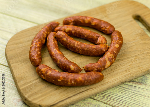 Smoked natural sausages on a wooden surface.