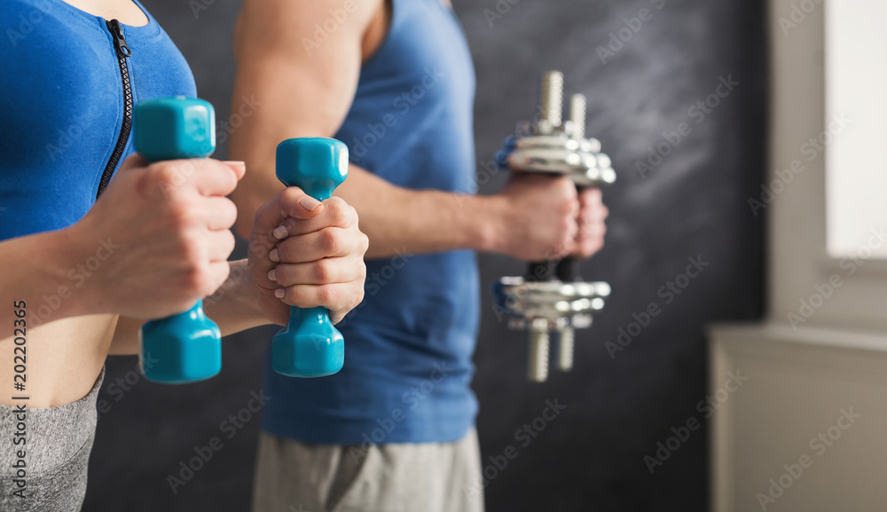 Fitness couple making exercise with dumbbells Fitness couple making exercise with dumbbells