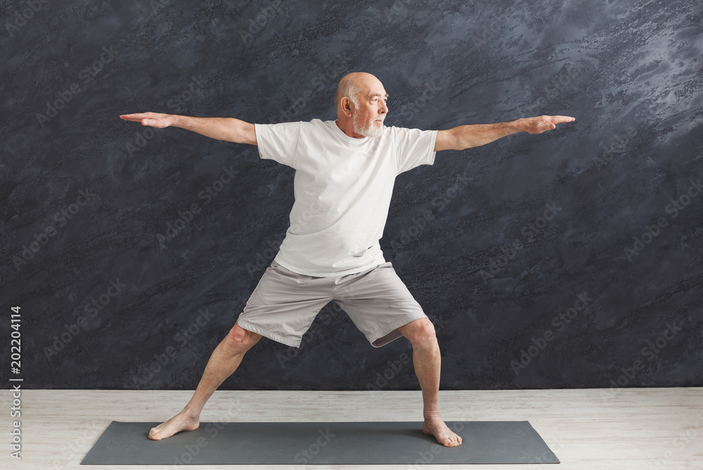 Senior man practicing yoga indoors