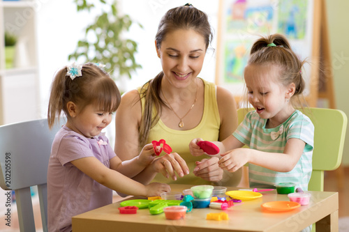 Children and their mom playing colorful clay toy