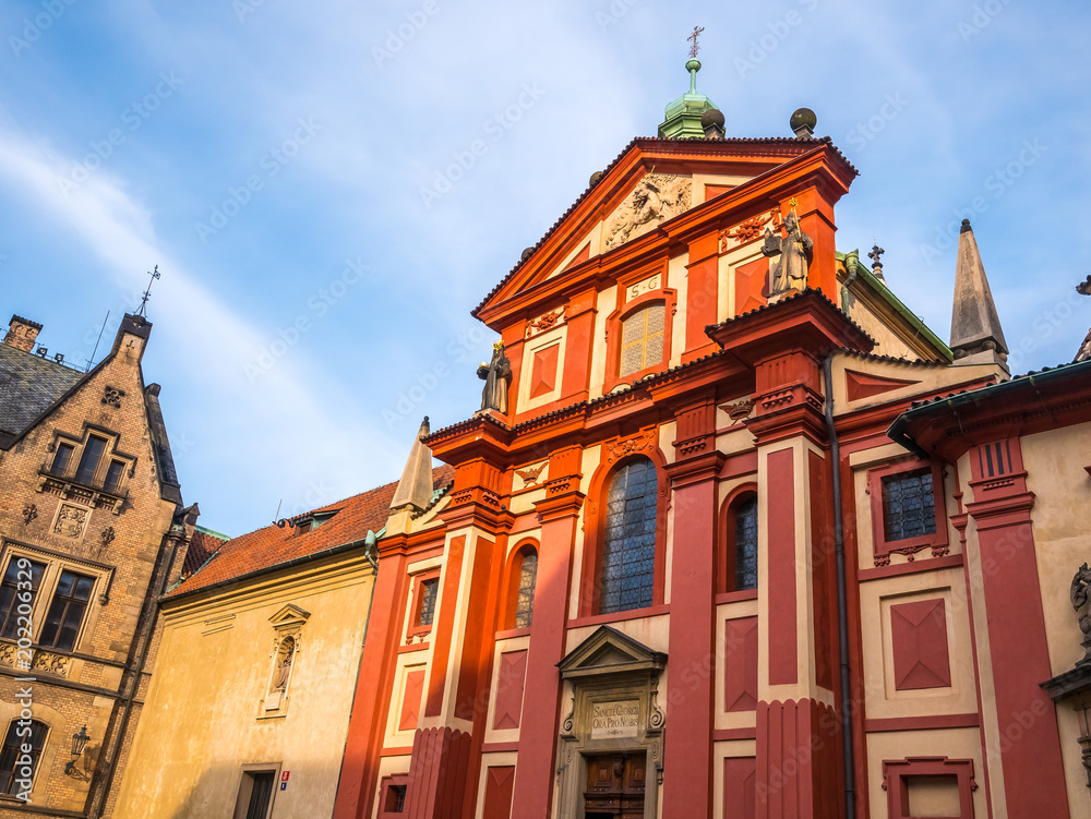 Fototapeta premium PRAGUE, CZECH REPUBLIC - FEBUARY 19, 2018 : St. George's Basilica in Prague Castle front view of the main entrance in Prague, Czech Republic.Blue sky sunny background winter season.Landmark historical