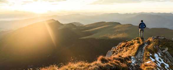 Silhouette of the man on top the peak of mountain on sunrise sky , Sport and active life conceptual design.