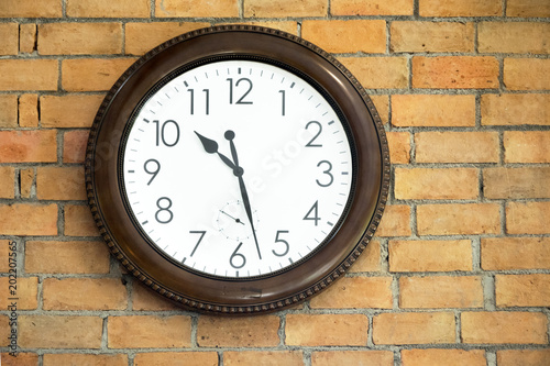 vintage clock hanging on an brick wall