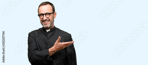 Canvas Print Priest religion man holding something in empty hand isolated over blue backgroun