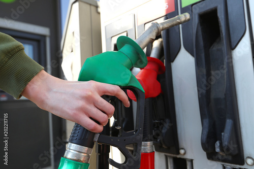 Woman filling her car with petrol at gas statiion photo