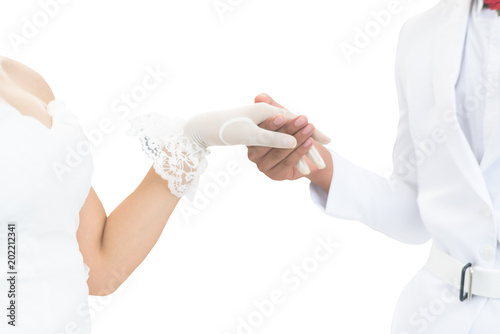 Asian bride in white wedding dress and groom in white suit holding hands isolated on white background photo