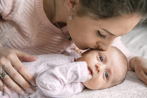 Beautiful young mom with 1 months baby at home photo