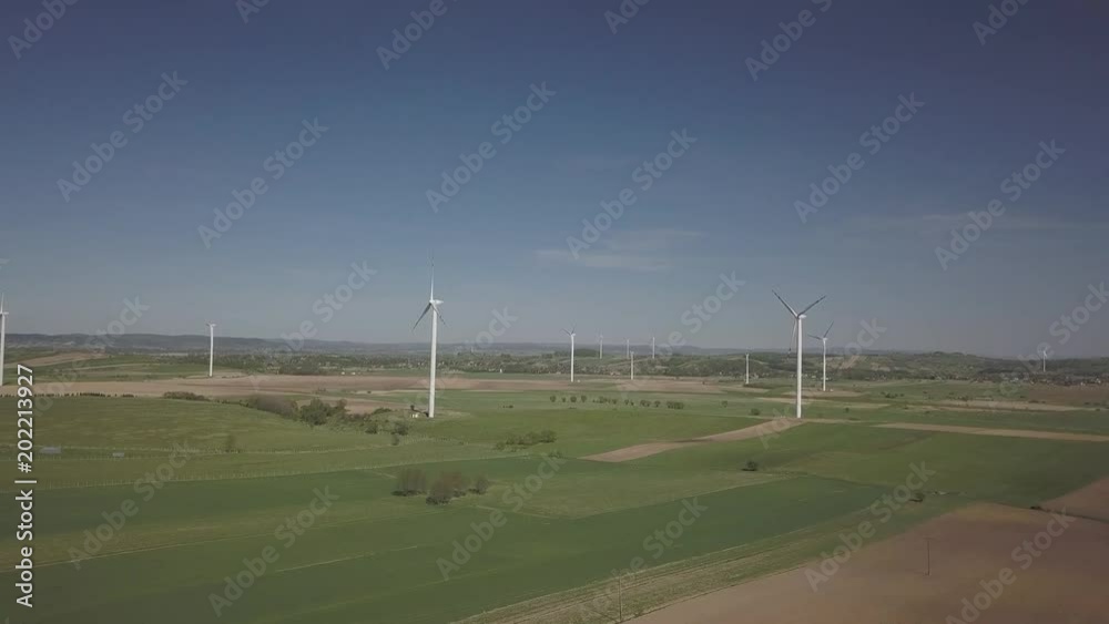 Flight near a wind power station in the daytime in the spring. Rotating blades of energy generators. Ecologically clean electricity. Modern technologies for the use of natural resources. Flight near a wind power station in the daytime in the spring. Rotating blades of energy generators. Ecologically clean electricity. Modern technologies for the use of natural resources.