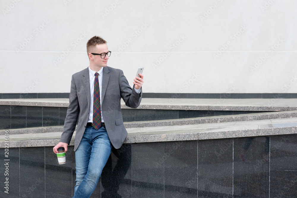 businessman, dressed in grey jacket, blue jeans, white shirt and tie have a  lunch break near buisness center, drink coffee, talking on the phone Stock  Photo | Adobe Stock