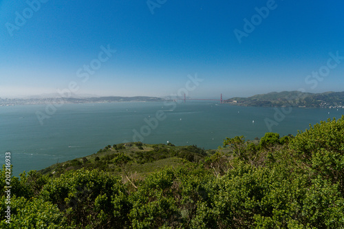 Wide sweeping view of the Golden Gate Bridge, city of San Francisco, and surrounding bay seen from up high on Angel Island