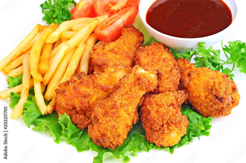 Chicken wings and drumsticks with french fries, barbecue sauce and vegetables Chicken wings and drumsticks with french fries, barbecue sauce and vegetables